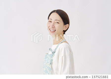 一位穿著圍裙的女子，白色背景，肖像照，看向鏡頭 137521881