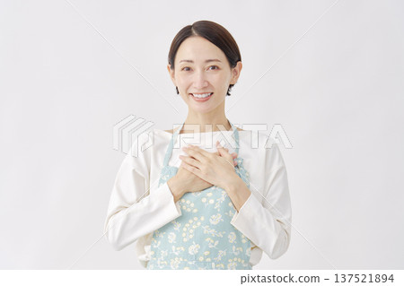 A woman wearing an apron feeling relieved, white background A woman wearing an apron feeling relieved, white background 137521894