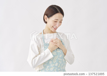 A woman wearing an apron feeling relieved, white background A woman wearing an apron feeling relieved, white background 137521895