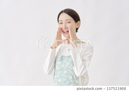 A woman wearing an apron talking on a white background 137521908