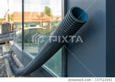 Black corrugated plastic conduit pipe for electrical wiring or cable protection at a building infrastructure site. Black corrugated plastic conduit pipe for electrical wiring or cable protection at a building infrastructure site. 137522041