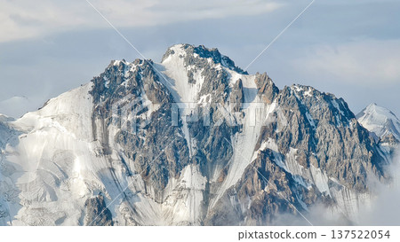 Close-up of the north face of Peak Ordzhonikidze with steep couloirs and ice fields in Trans-Ili Alatau. Close-up of the north face of Peak Ordzhonikidze with steep couloirs and ice fields in Trans-Ili Alatau. 137522054