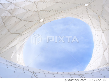 A view of the blue sky through the opening of a geometric membrane structure A view of the blue sky through the opening of a geometric membrane structure 137522102