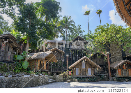 Wooden huts covered with straw of the ancient Miao tribe village in tropical forest in China Wooden huts covered with straw of the ancient Miao tribe village in tropical forest in China 137522524