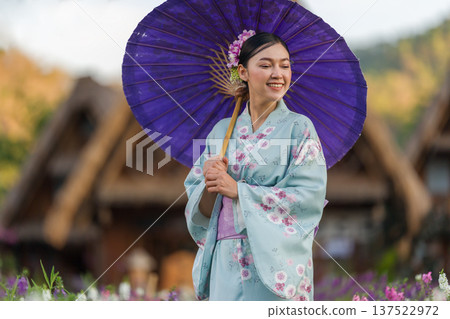 woman in yukata (kimono dress) holding umbrella with angelonia flower blooming in garden woman in yukata (kimono dress) holding umbrella with angelonia flower blooming in garden 137522972