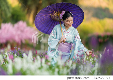 woman in yukata (kimono dress) holding umbrella with angelonia flower blooming in garden woman in yukata (kimono dress) holding umbrella with angelonia flower blooming in garden 137522975