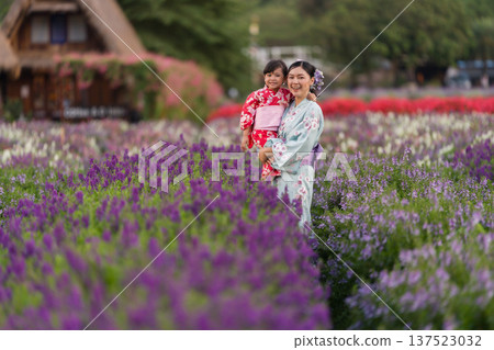 woman and child girl in yukata (kimono dress) with flower blooming in garden woman and child girl in yukata (kimono dress) with flower blooming in garden 137523032