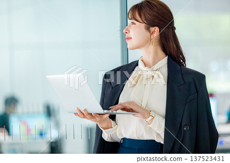 Young businesswoman working on a laptop in the office Young businesswoman working on a laptop in the office 137523431