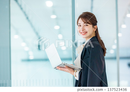在辦公室使用筆記型電腦的年輕女商人 137523436