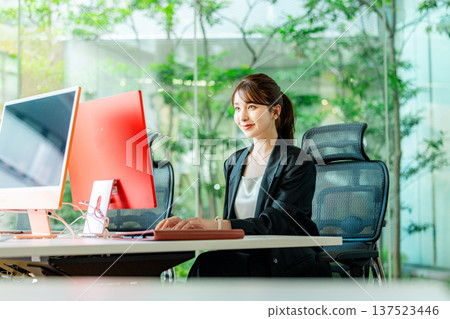 使用計算機的年輕女商人在辦公室 137523446