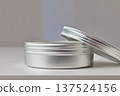 Opened  a gray cosmetic jar with lid 137524156