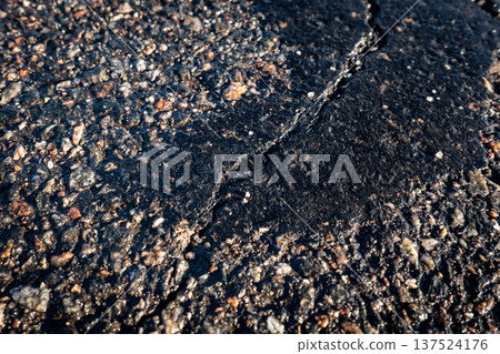 Cracked Asphalt Road Surface Texture Closeup Showing Damaged Pavement Detail Cracked Asphalt Road Surface Texture Closeup Showing Damaged Pavement Detail 137524176