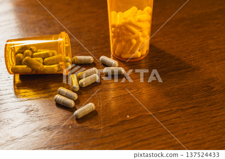 Collection of medicine capsules in orange containers on table 137524433