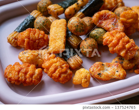 Assorted Japanese Rice Crackers and Snacks Mix Arare Senbei with Seaweed on White Plate - Traditional Asian Savory Snack Food 137524765
