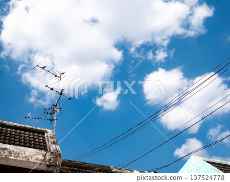 Old TV Antenna on Roof with Blue Sky and White Clouds Background Old TV Antenna on Roof with Blue Sky and White Clouds Background 137524778