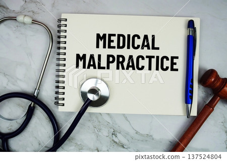 Medical Malpractice text written on notepad with stethoscope and gavel on marble background Medical Malpractice text written on notepad with stethoscope and gavel on marble background 137524804