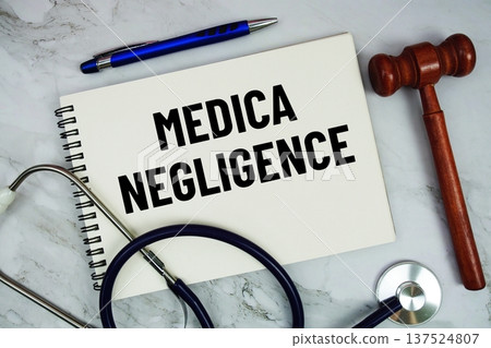 Medical Negligence text written on notepad with stethoscope and gavel on marble background Medical Negligence text written on notepad with stethoscope and gavel on marble background 137524807