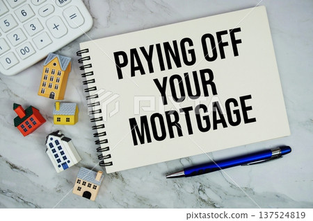 Paying Off Your Mortgage text written on notepad with house model on marble background Paying Off Your Mortgage text written on notepad with house model on marble background 137524819