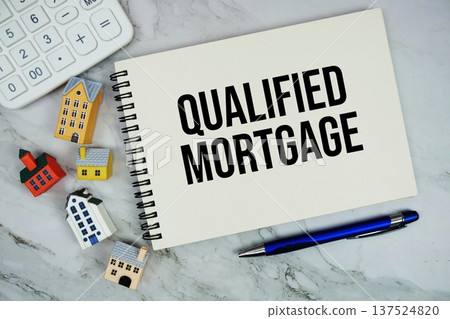 Qualified Mortgage text written on notepad with house model on marble background Qualified Mortgage text written on notepad with house model on marble background 137524820