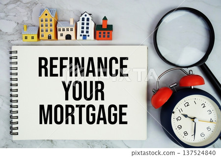 Refinance Your Mortgage text written on notepad with house model, magnifying glass and alarm clock on marble background Refinance Your Mortgage text written on notepad with house model, magnifying glass and alarm clock on marble background 137524840