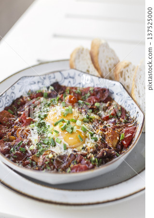 Shakshuka brunch dish on white table at outdoors restaurant in israel 137525000