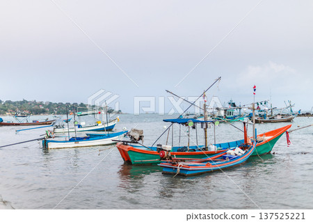 Traditional fishing boats anchored near tropical coastline in Thailand Traditional fishing boats anchored near tropical coastline in Thailand 137525221