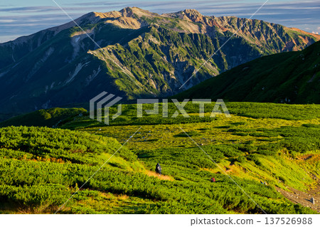 View of Mt. Yakushi with hikers on the traverse to Mt. Mitsumatarenge in the Northern Alps View of Mt. Yakushi with hikers on the traverse to Mt. Mitsumatarenge in the Northern Alps 137526988