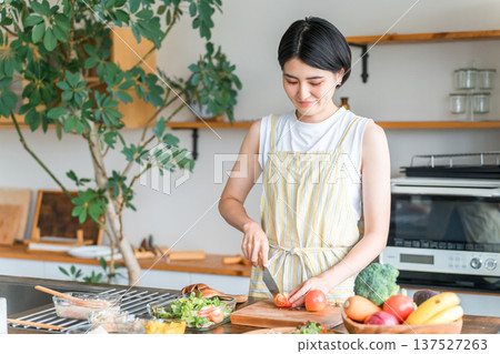 Young Asian woman cooking in the kitchen (cutting, knife, cooking, home cooking) 137527263