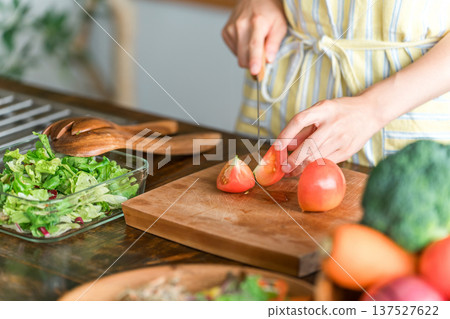 Young Asian woman cooking in the kitchen (cutting, knife, cooking, home cooking) Young Asian woman cooking in the kitchen (cutting, knife, cooking, home cooking) 137527622