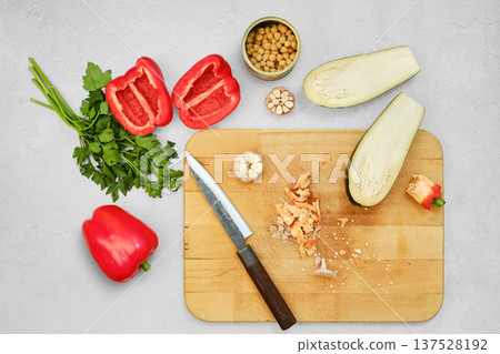 Red bell peppers, eggplant and garlic are chopped on a wooden cutting board Red bell peppers, eggplant and garlic are chopped on a wooden cutting board 137528192