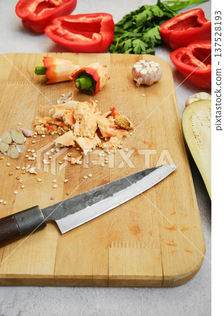 Red bell peppers and garlic on a wooden cutting board ready for cooking in a kitchen setting Red bell peppers and garlic on a wooden cutting board ready for cooking in a kitchen setting 137528193