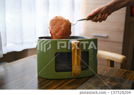 Cooked food is lifted from a green appliance in a kitchen during daytime Cooked food is lifted from a green appliance in a kitchen during daytime 137528204
