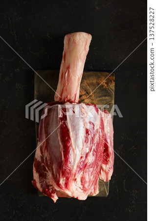 Butcher block with uncooked beef shank meat cut ready for preparation in a kitchen setting 137528227