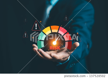 Businessman showing risk meter with warning triangles. Concept of risk management, financial assessment, security control, and business crisis prevention. 137528502