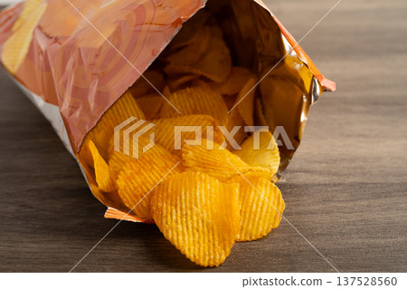 Potato chips, delicious BBQ seasoning spicy for crips, thin slice deep fried snack fast food in open bag. 137528560