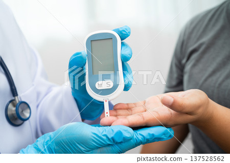 Doctor check diabetes from finger blood sugar level with finger lancet. Doctor check diabetes from finger blood sugar level with finger lancet. 137528562
