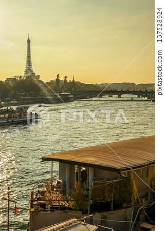 Eiffel Tower and Pont Alexandre III over Seine River with boat during a golden sunset in Paris, France 137528924