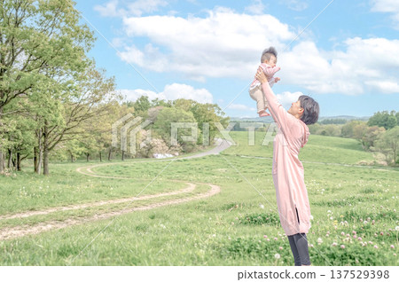 A happy moment between parents and children in a grassland with a blue sky 137529398
