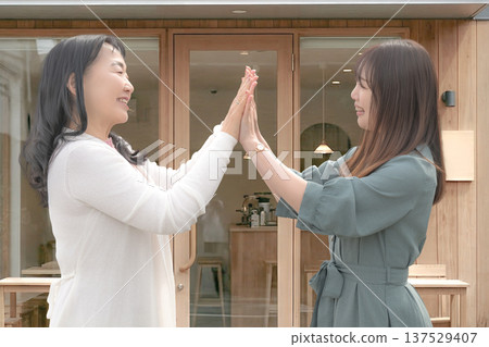 Two good friends holding hands in front of a cafe Two good friends holding hands in front of a cafe 137529407
