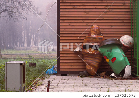 Abandoned cartoon characters and trash bin in a neglected urban park setting Abandoned cartoon characters and trash bin in a neglected urban park setting 137529572