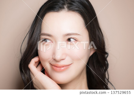 Beauty image of a young woman with beautiful black hair and a beige background. Image of skin care and other skin concerns. Beauty image of a young woman with beautiful black hair and a beige background. Image of skin care and other skin concerns. 137529655
