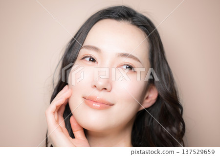 Beauty image of a young woman with beautiful black hair and a beige background. Image of skin care and other skin concerns. 137529659