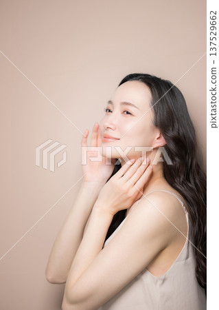 A beauty image of a young woman with beautiful black hair and a glossy, clear look against a beige background. Profile A beauty image of a young woman with beautiful black hair and a glossy, clear look against a beige background. Profile 137529662