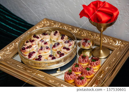 Catering serving elegant appetizers and canapes on golden trays 137530601