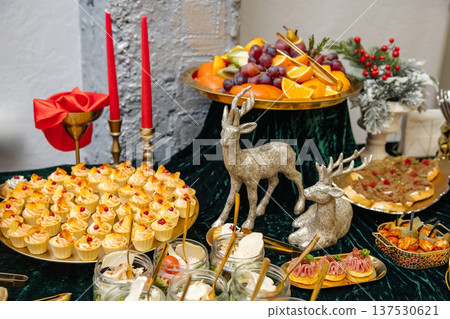 Holiday buffet table with various finger foods and seasonal decor Holiday buffet table with various finger foods and seasonal decor 137530621