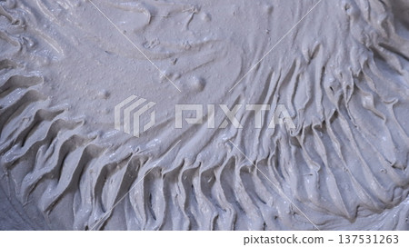 Gray thick viscous mortar with a circular ribbed pattern on a soft surface as an abstract textured empty background, mixed construction mixture of putty or plaster with a beautiful texture Gray thick viscous mortar with a circular ribbed pattern on a soft surface as an abstract textured empty background, mixed construction mixture of putty or plaster with a beautiful texture 137531263