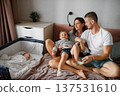 Loving Parents Playing With Son Beside Sleeping Baby 137531610