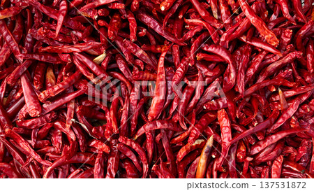 Top view of vibrant dried red chili peppers spread out to dry in the sun. Sun dried spicy Thai chilies texture an essential ingredient in Asian cuisine and traditional food preservation. Top view of vibrant dried red chili peppers spread out to dry in the sun. Sun dried spicy Thai chilies texture an essential ingredient in Asian cuisine and traditional food preservation. 137531872