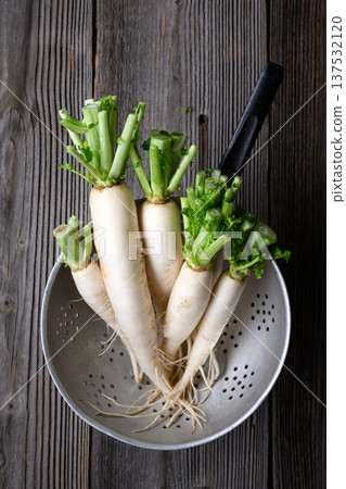 Fresh daikon radish washed in metal strainer Fresh daikon radish washed in metal strainer 137532120