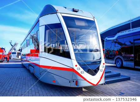 New modern tram stands at exhibition in city. A modern low-floor tram is parked at exhibition. 137532346